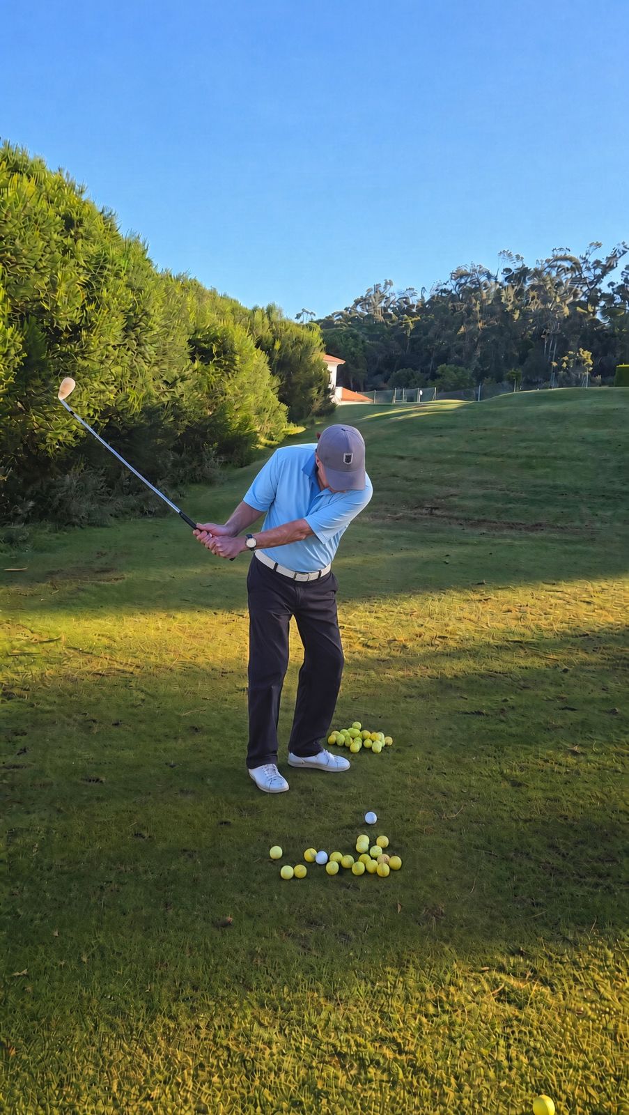 Gordon Young hitting a golf ball on the practice ground in soft morning light